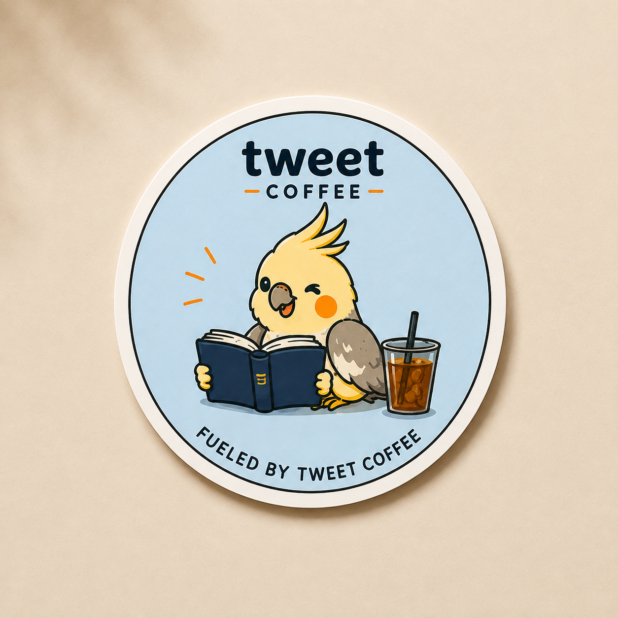 Tweet Coffee Fueled by Tweet Coffee sticker with bird reading a book beside an iced coffee